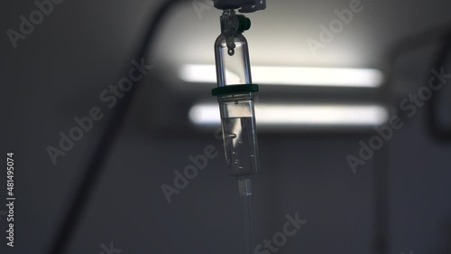 Wallpaper Mural Dolly zoom of an IV drip fluid with white lights int he background. Close up shot of intravenous therapy in a dark white hospital room. Intravenous line with drops falling while doing zoom out. Torontodigital.ca