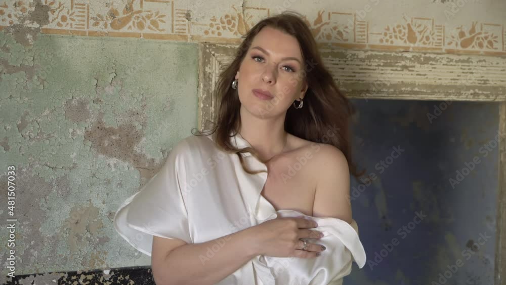 Young woman in robe in abandoned building posing in room. Ghost town Kolmanskop.