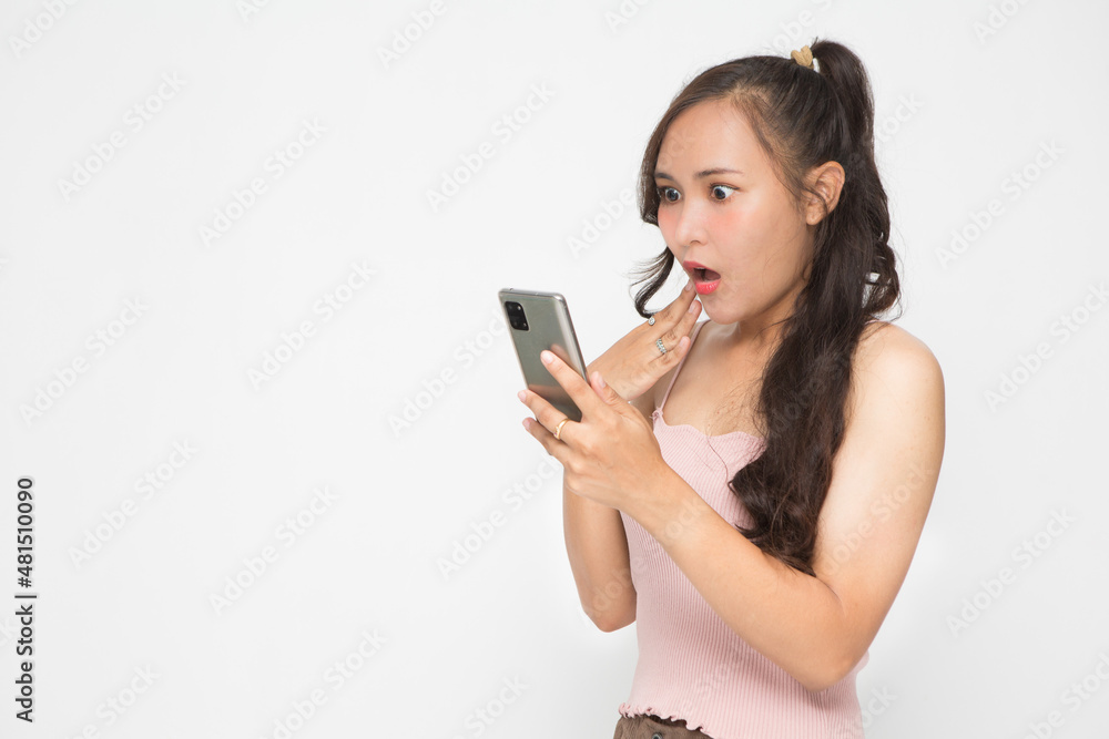 Cute Asian woman is shocked something on her smartphone for social media concept Cute Asian woman is shocked something on her smartphone for social media concept