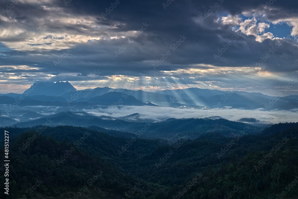 Light ray over blue mountain range silhouette with blue sky cloud in a morning