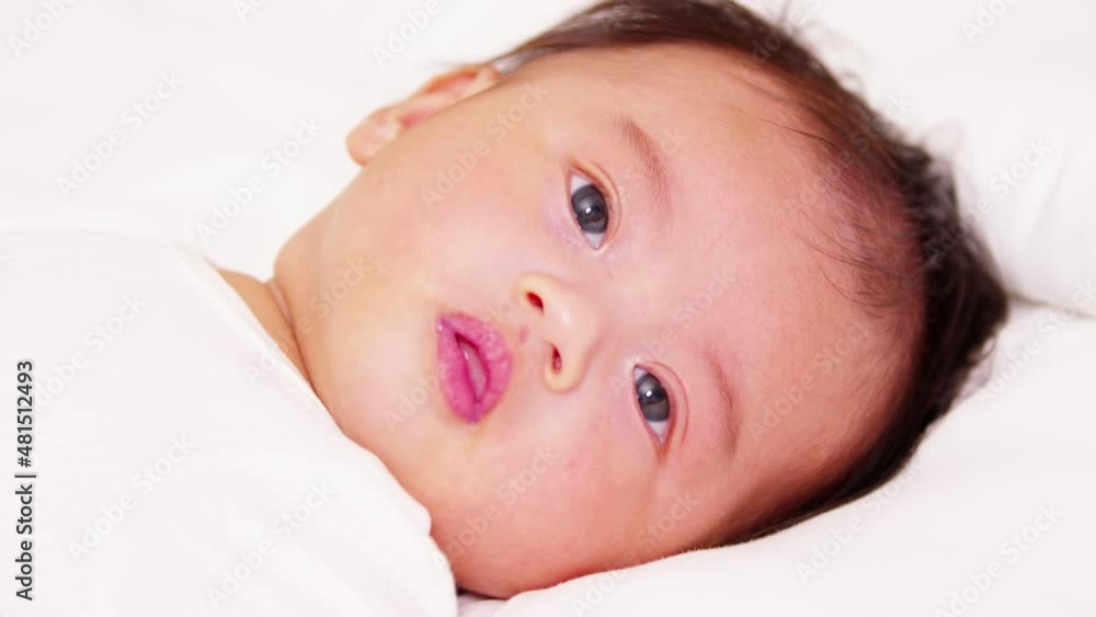 happy newborn baby lying on a white bed and blanket comfortable and safety.Cute Asian newborn looking around on bed.Newborn Baby Care concept happy newborn baby lying on a white bed and blanket comfortable and safety.Cute Asian newborn looking around on bed.Newborn Baby Care concept
