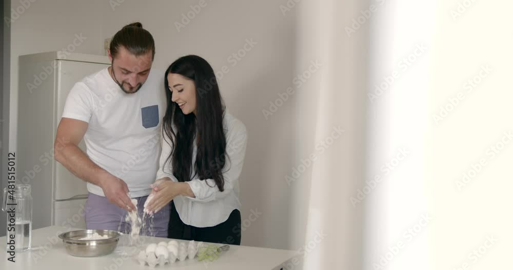 Happy young woman and man baking together Happy young woman and man baking together