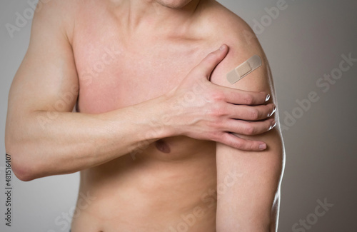 Shoulder pain. The man's shoulder hurts. A Band-Aid