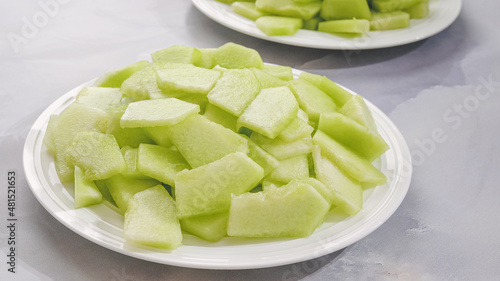 Honeydew melon slices close up on a plate, fruit salad