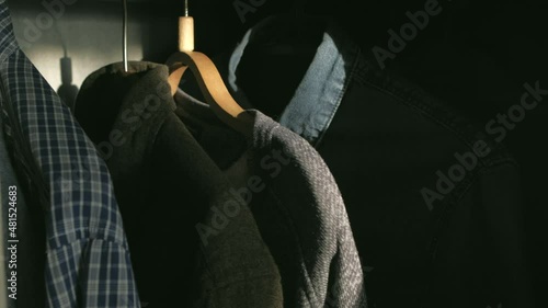 Closeup - Man takes shirt in the wardrobe at sunny morning at home.Morning get ready for work concept.