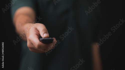 Man's hand holding a smart tv remote control.Remote control in hand closeup.