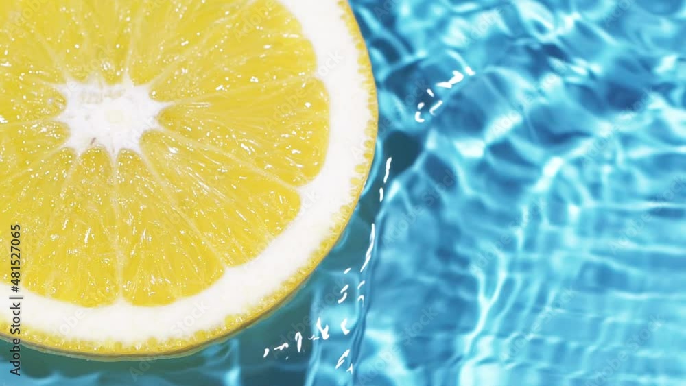 Macro orange fruit slice and blue water surface texture with ripples and splash Macro orange fruit slice and blue water surface texture with ripples and splash