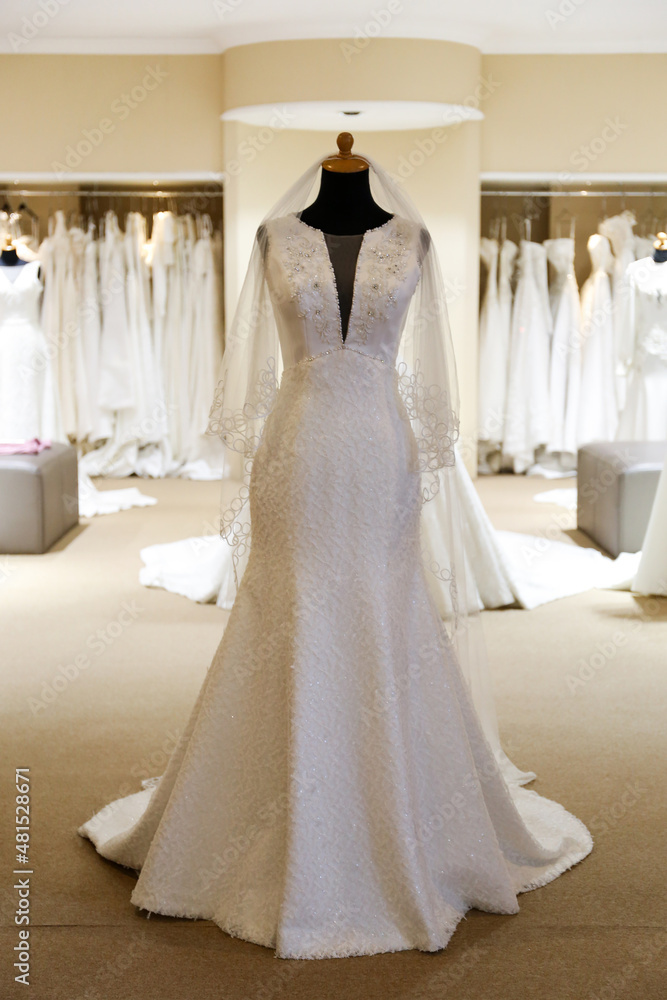 Beautiful white wedding dress gown on mannequin in boutique Beautiful white wedding dress gown on mannequin in boutique