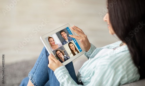 Middle-eastern woman having video conference with multiracial friends, using tablet