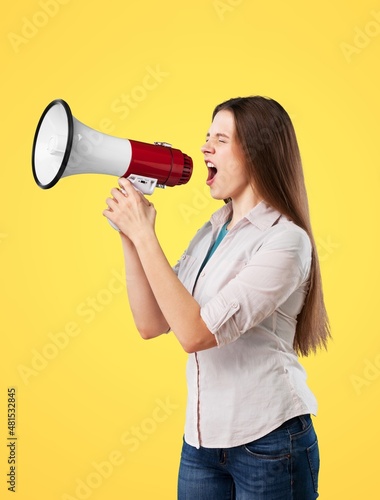 a beautiful excited young woman shouting holding a megaphone