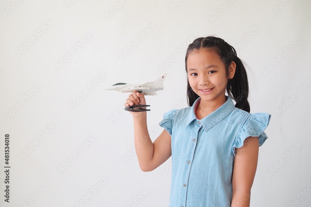 Two Asian kids holding airplane model standing over white background. Two Asian kids holding airplane model standing over white background.