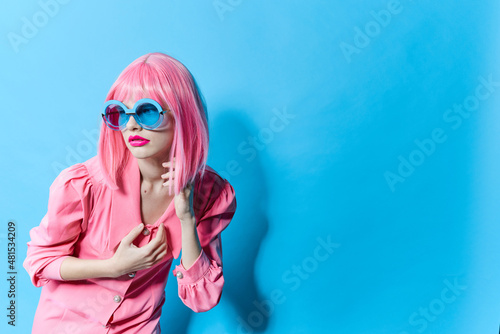 pretty woman in blue glasses wears a pink wig studio model unaltered