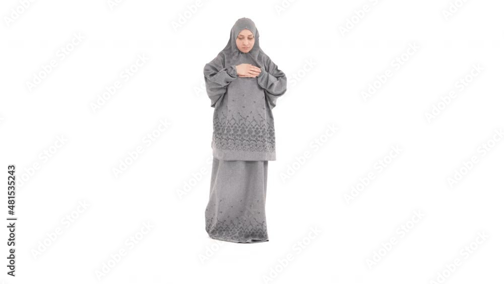 Full height Muslim woman praying in traditional prayer dress. Isolated on a white background. Full height Muslim woman praying in traditional prayer dress. Isolated on a white background.