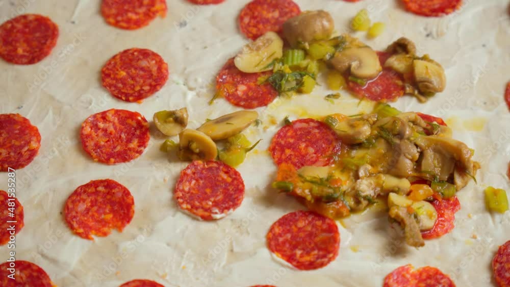 Cooking pizza with salami and mushrooms close-up. Pizza ingredients.