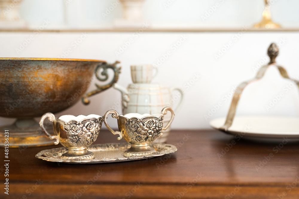Interior detail with antique cabinet and exquisite ceramic, glass and metal dishes - selective focus