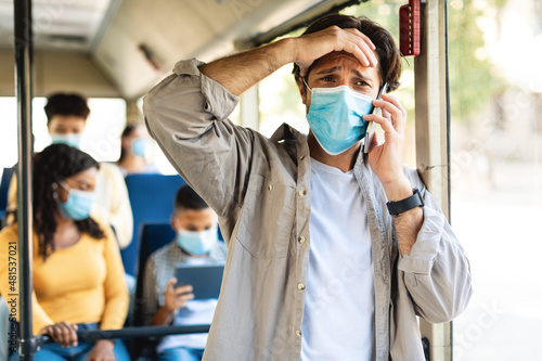 Shocked guy talking on phone in public transport