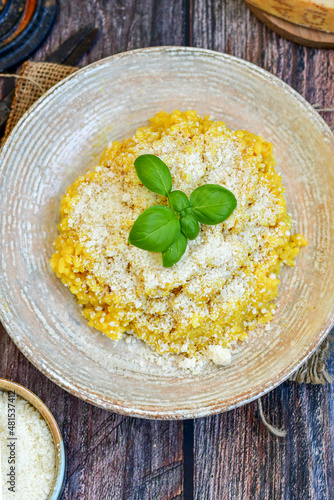 Photo Italian  home made  creamy risotto milanese  with parmesan cheese and fresh bas