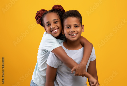 Cute black teen girl hugging brother, showing her affection