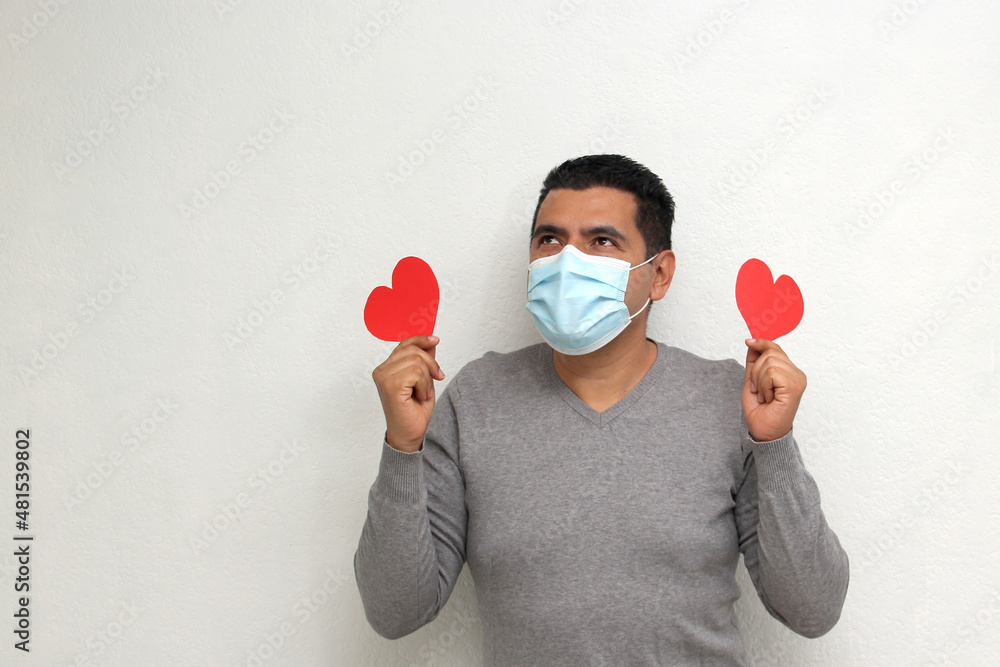 Latino adult man with face mask as protection in the new normality due to the Covid-19 pandemic shows a red heart to celebrate Valentine's Day of Love and Friendship
Latino adult man with face mask as protection in the new normality due to the Covid-19 pandemic shows a red heart to celebrate Valentine's Day of Love and Friendship