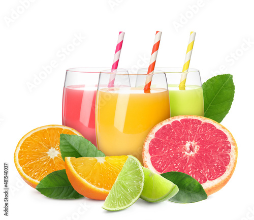 Glasses of different citrus juice, fresh fruits and green leaves on white background