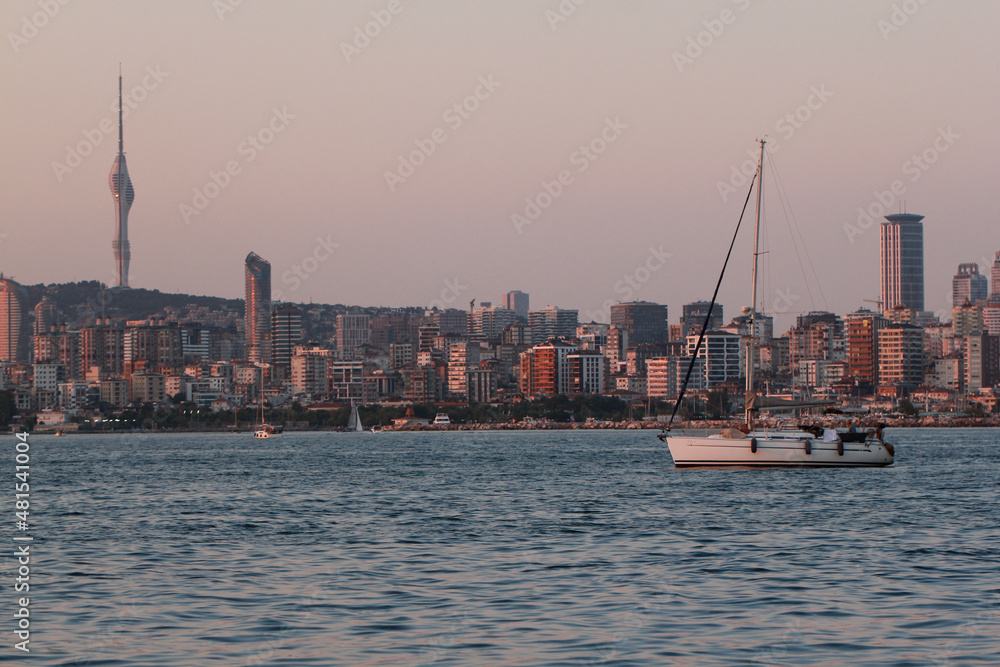 Naklejka premium Yacht in the marble sea overlooking the evening Istanbul and Camlica Hill