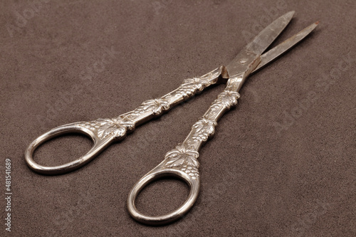 antique silver scissors with a slight blur on the tips on a brown velvet background photo