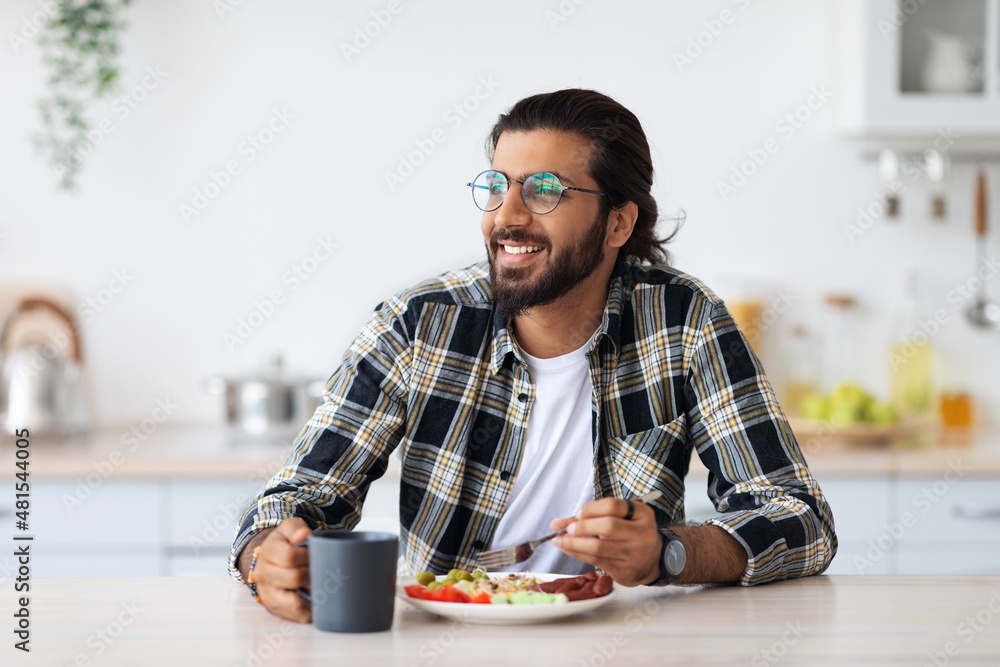 Happy middle-eastern young man enjoying healthy lunch at home Happy middle-eastern young man enjoying healthy lunch at home