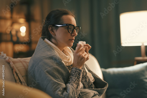 Sick woman with cold resting at home photo