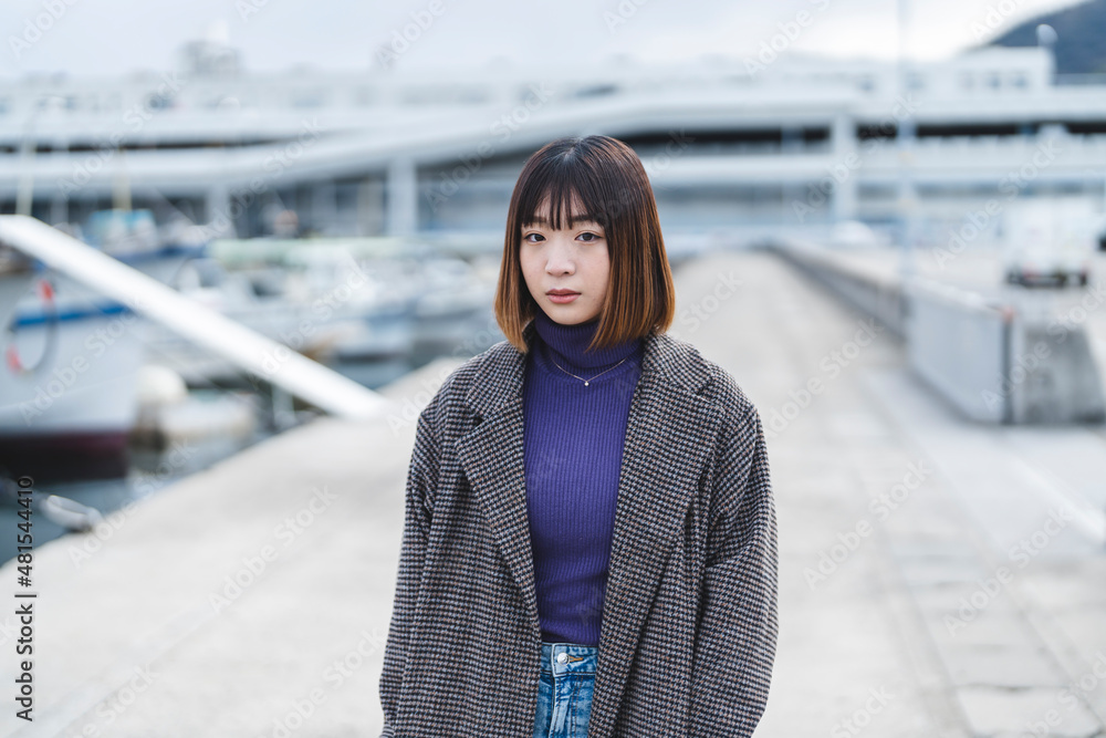 Obraz premium 港を散策する若い女性