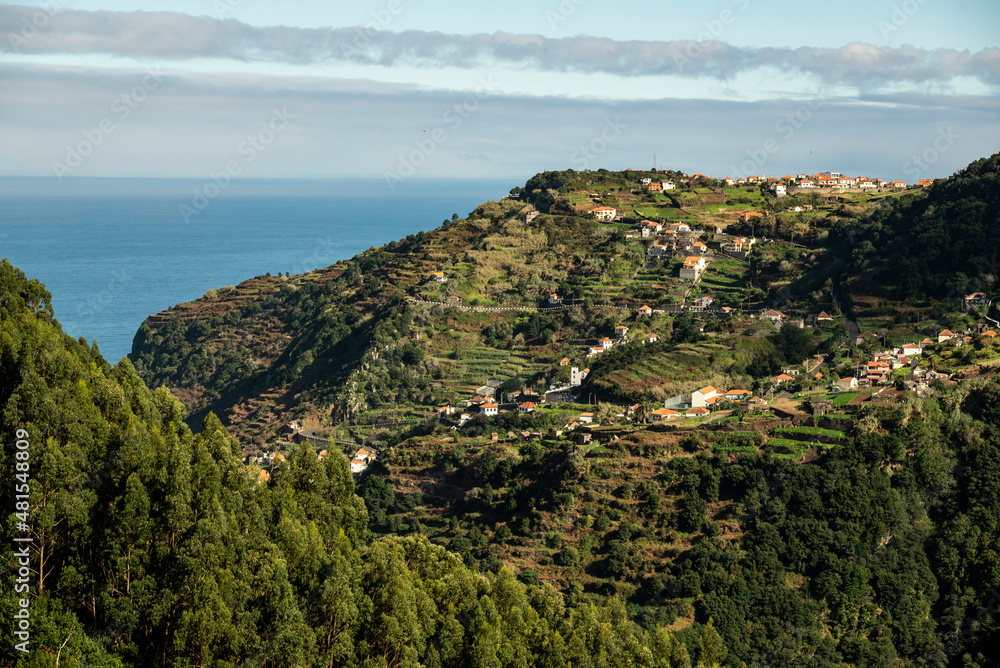 Panoramic view of the houses of Ribeira da Janela village and the surrounding terraced landscape, seen from the “Levada da Ribeira da Janela” hiking trail, Madeira, Portugal