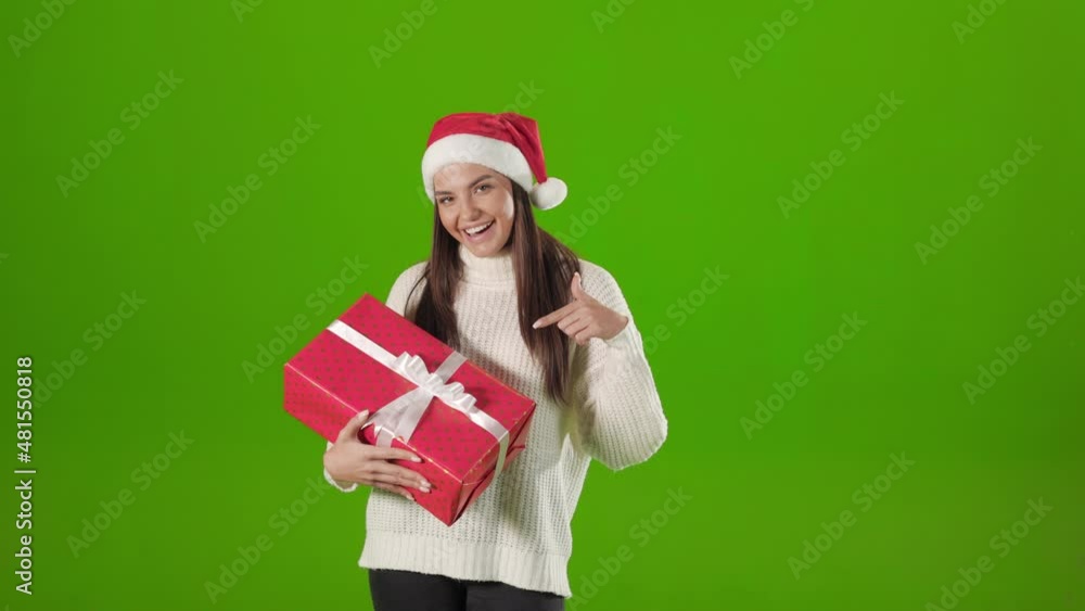 Woman in santa hat pointing on christmas box Woman in santa hat pointing on christmas box