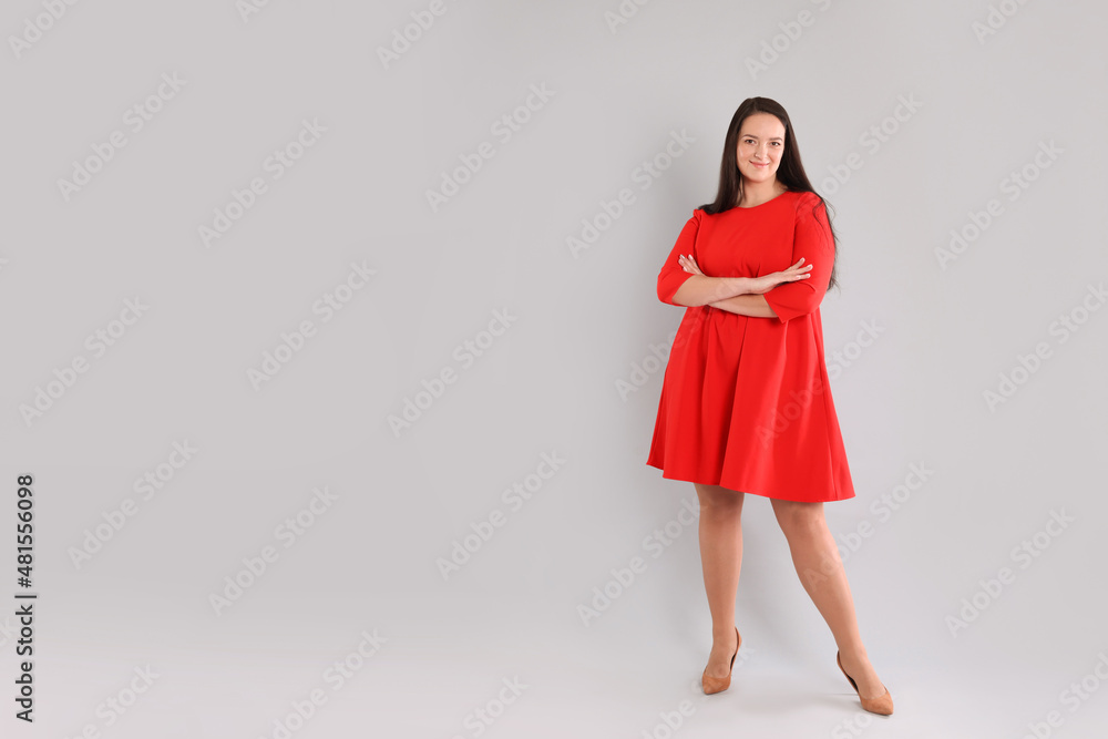 Beautiful overweight woman in red dress on light grey background. Space for text Beautiful overweight woman in red dress on light grey background. Space for text