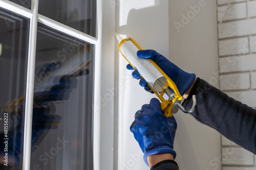 Cuadro en lienzo Worker is applying polyurethane foam to fill gap between sash and window frame
