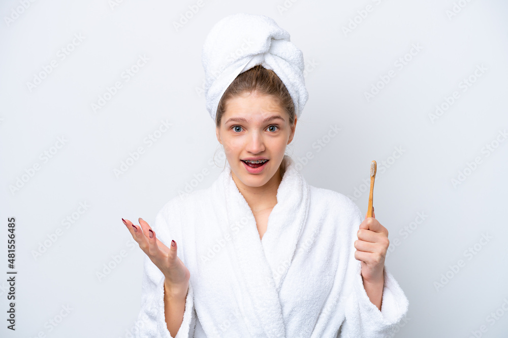 Teenager Russian girl brushing teeth isolated on white background with shocked facial expression Teenager Russian girl brushing teeth isolated on white background with shocked facial expression