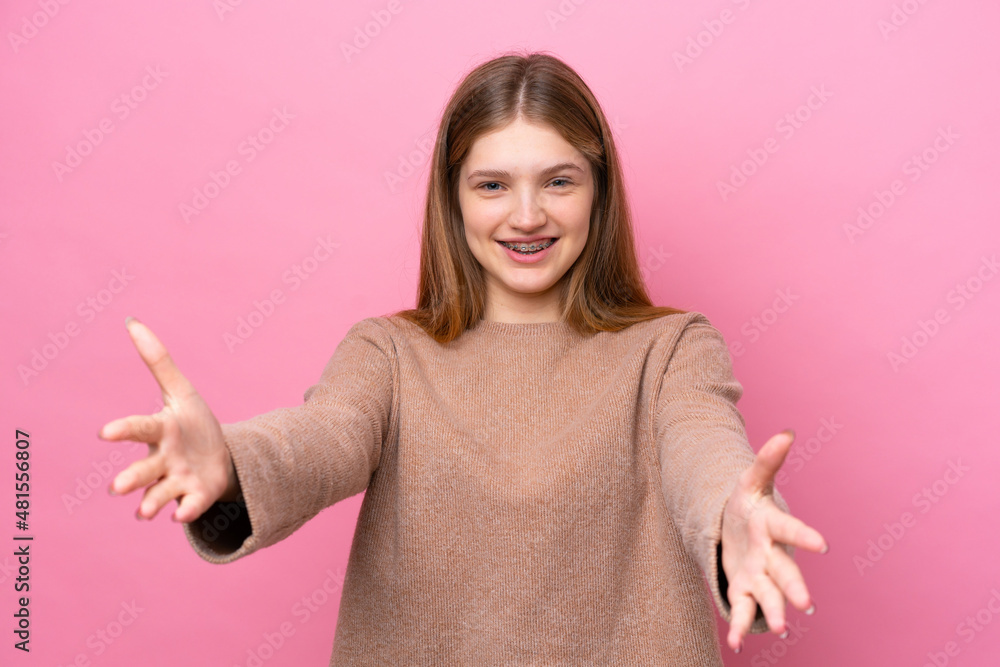 Teenager Russian girl isolated on pink background presenting and inviting to come with hand Teenager Russian girl isolated on pink background presenting and inviting to come with hand