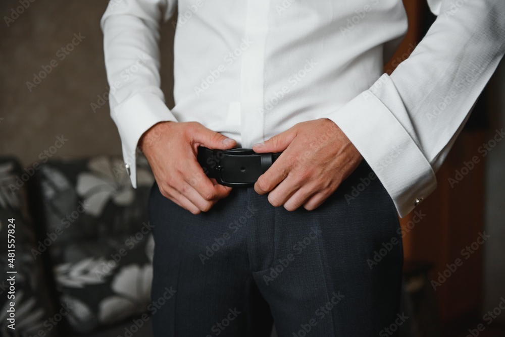 A man fastens buttons on his shirt. A man fastens buttons on his shirt.