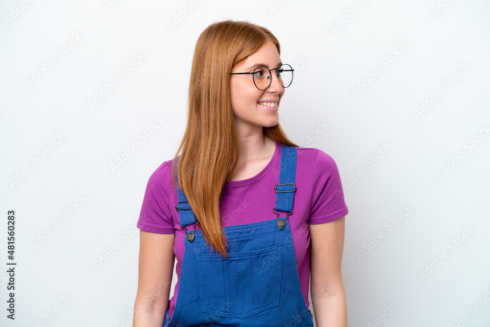 Young redhead woman isolated on white background looking side Young redhead woman isolated on white background looking side