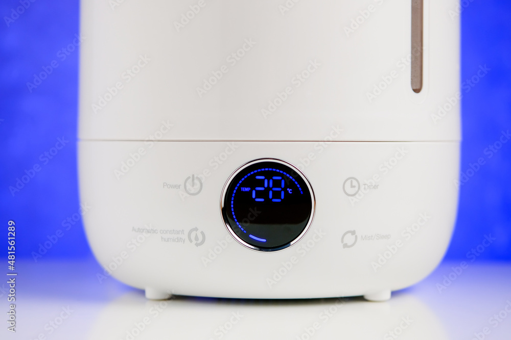 Screen modern ultrasonic ionizer humidifier on table on blue background. Screen modern ultrasonic ionizer humidifier on table on blue background.