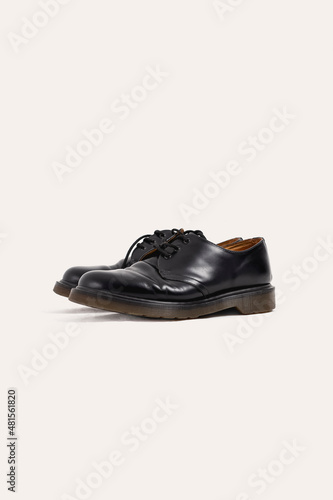 Old black shoes on a white background. Side view