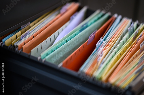 document file paperwork in files placed in the filing cabinet