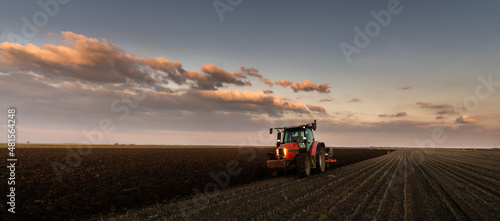Tractor on the field during sunset.