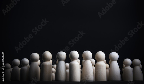 Wooden doll on black background. concept of teamwork. Staff team. Personnel in organization. Successful corporate leadership