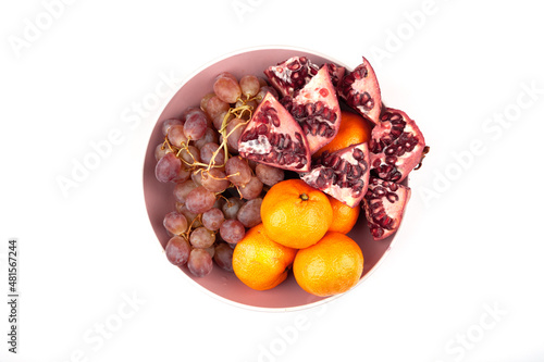 Delicious grapes and oranges. they stand in a round vase. for a festive table. great pitch. fruit in a plate. on an isolated white background. top view. close-up. food. Fruit concept photo