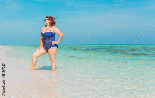 Body positive concept. Middle age lady at the beach in blue swimsuit resting and have a nice time © T.Den_Team