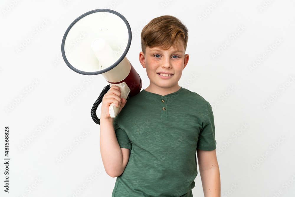 Little redhead boy isolated on white background holding a megaphone and smiling a lot Little redhead boy isolated on white background holding a megaphone and smiling a lot
