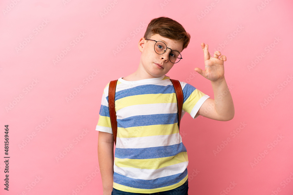 Little redhead caucasian boy isolated on pink background with fingers crossing and wishing the best Little redhead caucasian boy isolated on pink background with fingers crossing and wishing the best