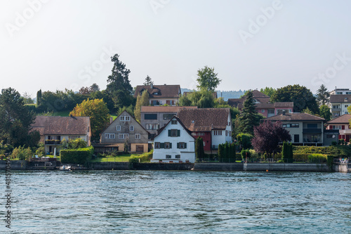 Rhine river and the coastline with trees and houses in Stone at the Rhein town on sunny summer day