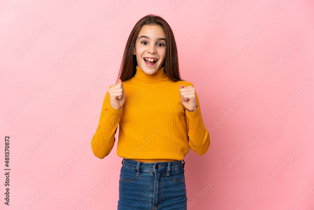 Little girl isolated on pink background celebrating a victory in winner position Little girl isolated on pink background celebrating a victory in winner position