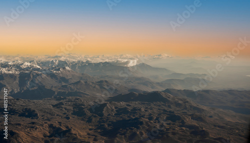 Aerial view of alps. Flying over Alps. Amazing view on mountain. sunset. mountains and blue sky at sunrise  view from above air plane window.
