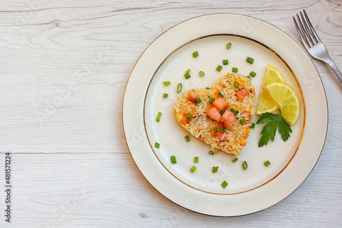 Heart shaped salmon fried rice,jasmine rice with smoked salmon,garlics,onions,spring onions,eggs and soy sauce on plate with wooden background.Love healthy food concept for Valentine's day.Top view